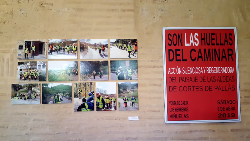 Galería de fografías en la pared junto a un cartel