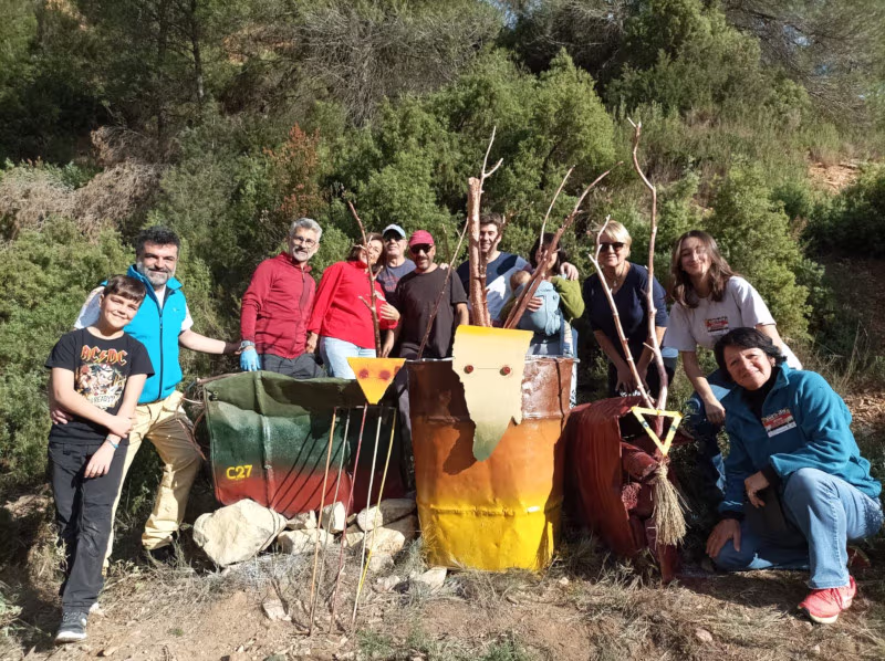 Grupo de personas posando con su obra de basura recuperada