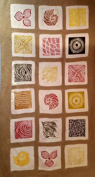 Foto de una tela con multiples grabados sobre fondos cuadrados