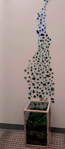 Foto de cristales de colores saliendo de una caja y trepando por la pared